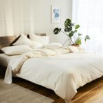 A warm wooden bed with soft sateen sheets in cream.